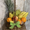 Basket of assorted fruit with a pineapple and green ribbon