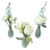 Three white floral arrangements in blue glass vases