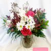 Bouquet of pink roses and white daisies in a glass vase