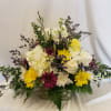 Mixed bouquet in a low rectangular container with white, yellow, and purple flowers