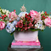 Mixed bouquet in a white ribbed vase with pink, blue, and white flowers