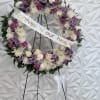 Floral memorial wreath on an easel with a ribbon reading "Forever in our hearts"