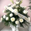 White rose and lily arrangement with a condolence ribbon