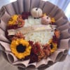 Bouquet of white roses with sunflowers and small pumpkins