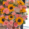 This beautiful floral arrangement combines the warmth and joy of sunflowers with