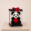 Panda-shaped floral gift in a clear box with a red ribbon and heart