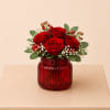 A romantic flower arrangement featuring premium red roses, accented with delicate spray