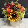 Mixed bouquet with sunflowers, roses, and hydrangea in a white vase