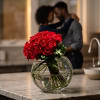 Red rose bouquet in a round glass vase on a countertop