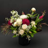 Mixed bouquet of white and deep pink flowers in a black vase