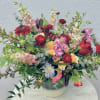 Large mixed bouquet in a round vase with red, pink, peach, and white flowers