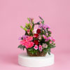 Basket arrangement of pink and red flowers with lilies and roses