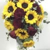 Bouquet of yellow sunflowers and burgundy roses in a clear vase