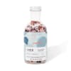 Bottle of aromatherapy bath soak with pink salt and dried petals
