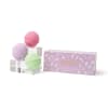 Three pastel bath bombs beside a purple gift box