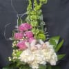 Tall floral arrangement with pink and white blooms in a glass vase