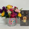 Mixed bouquet in a metal bucket beside a box of chocolates