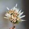Dried beige roses with white accents and pampas grass, wrapped in burlap