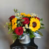 Bouquet of red roses, sunflowers, and small white daisies in a silver container