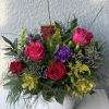 Colorful rose arrangement in a white textured vase with mixed filler flowers
