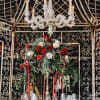 Red and white rose centerpiece on a formal table beneath a chandelier