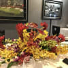 Low tropical centerpiece with red and yellow orchids on a table