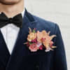 A modern, pocket square boutonniere featuring a premium rose accented with delicate