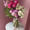 Bright pink roses and soft peony-like blooms create a layered, romantic bouquet