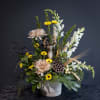 Mixed floral arrangement with yellow daisies, pale pink blooms, and a deer figurine in a vase