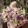 Large bouquet of purple, white, and cream roses in a white box