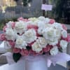Pink and white rose arrangement in a white hatbox