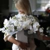 Woman holding a white orchid and rose bouquet in a box