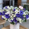Large bouquet of white and purple flowers in a white vase