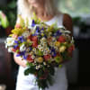 Woman holding a colorful bouquet of roses and daisies