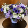 Bouquet of white and purple flowers in a lavender container
