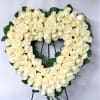 Heart-shaped wreath of white roses on a stand