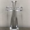 Clear glass cross figurine on a plain surface