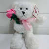 White plush teddy bear holding a pink fabric rose with a pink ribbon and gift tag