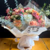 Bouquet of peach and pink roses with white hydrangea in clear wrap