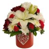 Red and white flower arrangement in a red heart-decorated box