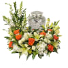 Floral funeral urn arrangement with orange roses and white lilies