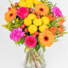 This hand tied arrangement is bursting with vibrant blooms, including yellow, cerise