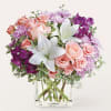 Pink roses and white lilies in a clear glass vase