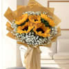 Bouquet of sunflowers wrapped in tan paper with white filler flowers