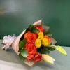 Bouquet of orange roses and yellow mums wrapped in pink paper