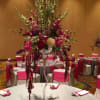 Tall floral centerpiece in a glass vase on a banquet table