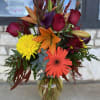 Mixed bouquet in a glass vase with roses, lilies, gerbera daisies, and chrysanthemums