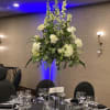 Tall white floral centerpiece on a banquet table