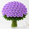 Large bouquet of lavender roses in a clear glass vase