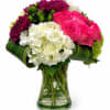 Bouquet of pink roses, white hydrangeas, and purple chrysanthemums in a glass vase